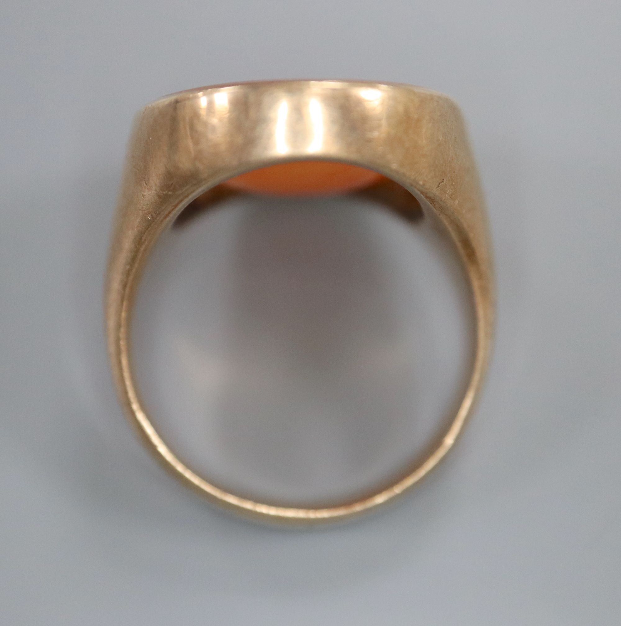 A late 19th century yellow metal and oval carnelian intaglio ring, carved with the head of a gentleman to sinister, size R,